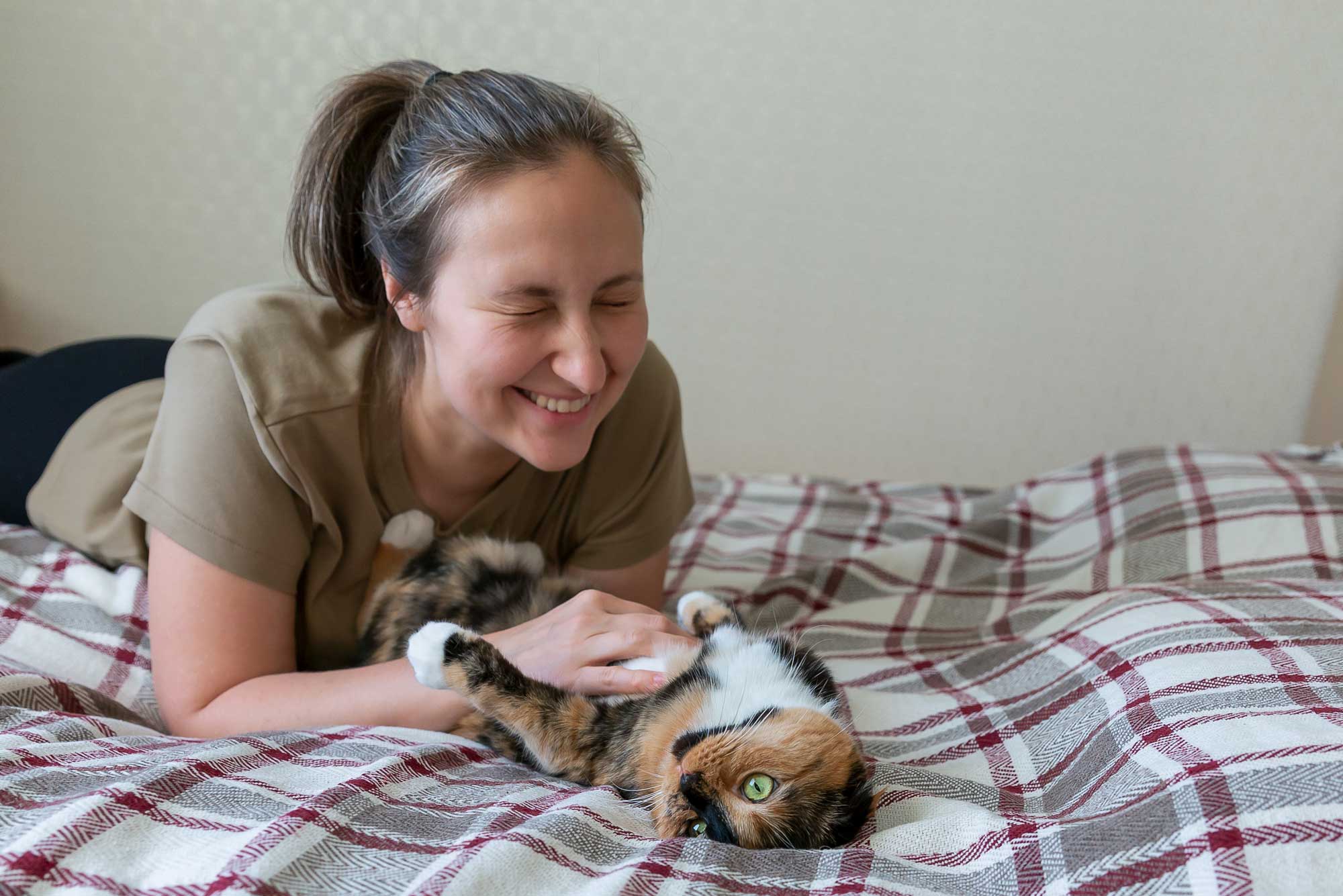 Woman playing with a cat on the floor